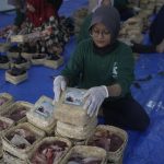 Pengemasan daging kurban dalam wadah besek, yang lebih ramah lingkungan. (Foto: Humas UMM)