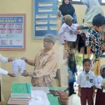 Anggota DPRK Aceh Timur, Tgk Suryadi, saat menyerahkan bantuan seragam di SD Negeri Matang Kruet, Kamis (17/7/2025). (Foto: Rizki Maulizar/ IST)