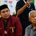 Erfanda Andi Mada Arectya (kiri) ketika mendampingi Ketua PP Muhammadiyah Busyro Muqoddas (kanan) dalam acara Kuliah Bersama Rakyat Pesisir Surabaya di SD Muhammadiyah 9 Sukolilo pada Kamis (10/4/2025). (Foto: Dok IMM Surabaya)