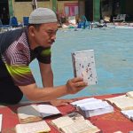 Dokumen dan arsip-arsip penting coba diselamatkan dengan dikeringkan di bawah terik matahari. (Foto: Dok.)